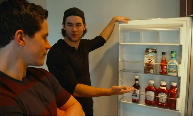 Tom Wilson showing his fridge as Michael Latta watches
